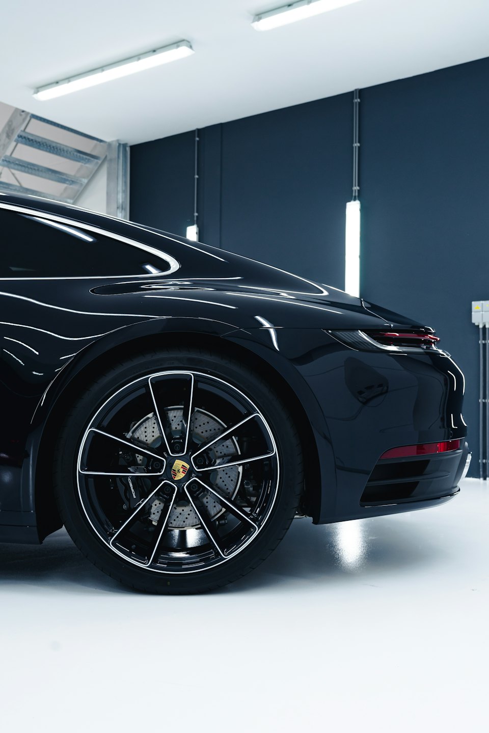 Sleek black sports car parked indoors with polished bodywork.